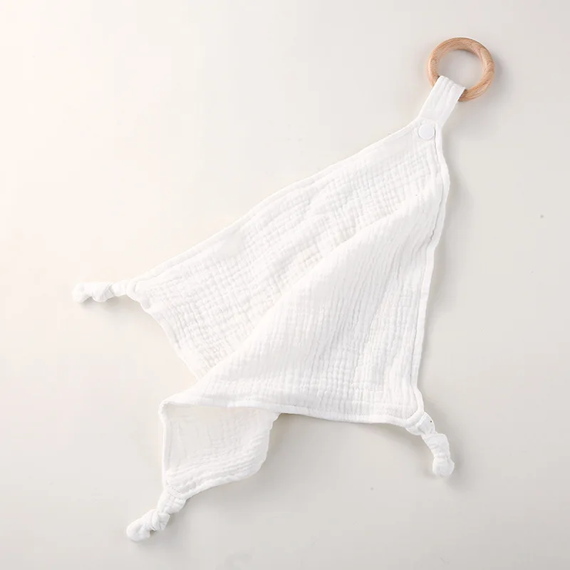 Couverture bébé en mousseline avec anneau en bois accessoire réconfort blanc pur texture douce design épuré