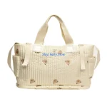 Sac à langer matelassé en tissu beige avec motifs nounours  Poche extérieure et fermeture éclair  Conçu pour maman et bébé  Design moderne et pratique