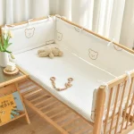 Berceau bébé moderne en bois blanc avec protections rembourrées motifs ours jouets en bois et peluche accessoires