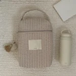 Sac isotherme pour poussette caddie et biberon tissu matelasse beige moderne minimaliste maman portage usage quotidien design pratique rangement protection aliments