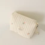 Pochette à cosmétiques en tissu matelassé avec broderie florale fermeture éclair anneau métallique style élégant idéale pour le rangement de bébé ou des affaires personnelles