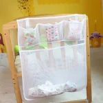 Organisateur de lit bébé tissu maille poches multicolores rangement pour couches jouets design moderne fonctionnel idéal chambre bébé